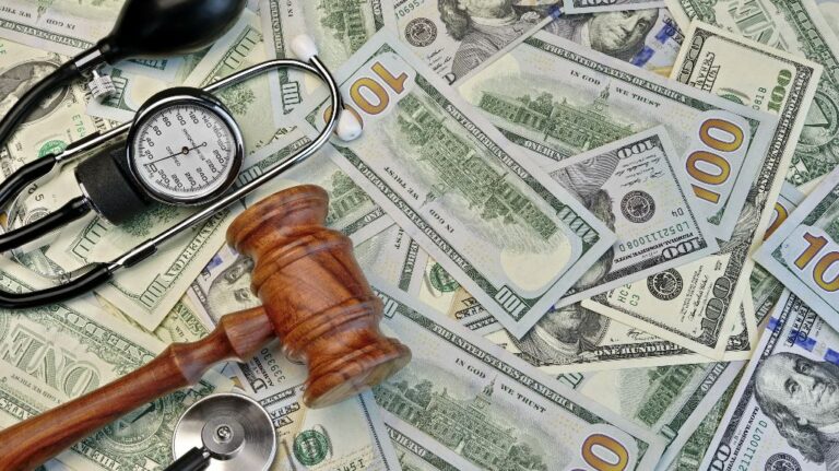 Judge's gavel and medical tools on the dollar cash background