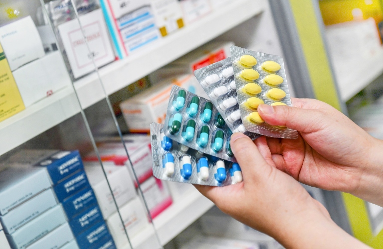 Hand holding medicine capsule pack at the pharmacy drugstore