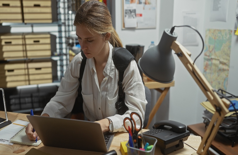 female police officer on laptop taking notes