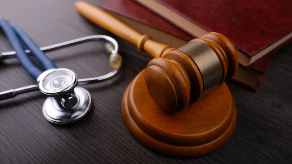 Gavel and stethoscope on wooden background